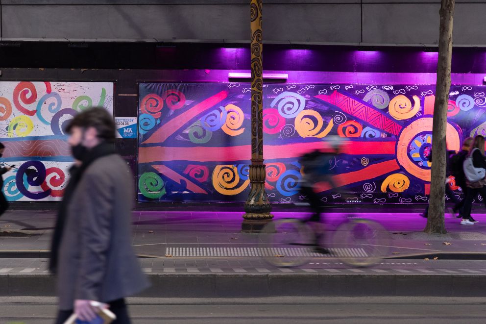 A mural is lit up by purple lights