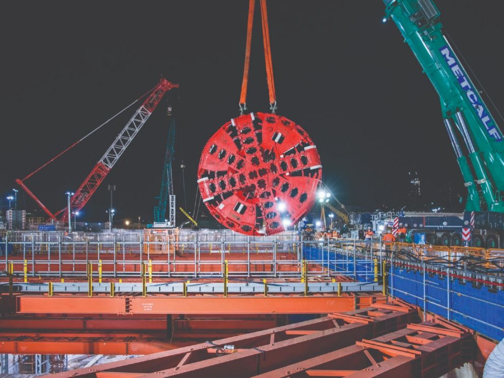The giant TBMs are lowered underground in sections to be assembled and launched.