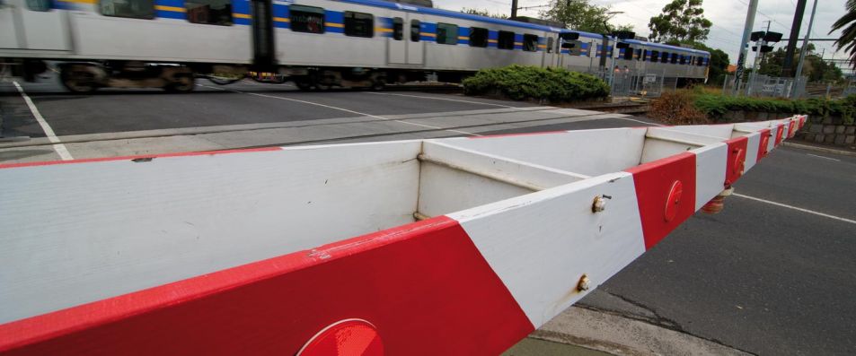 Boom gate down with train running through level crossing