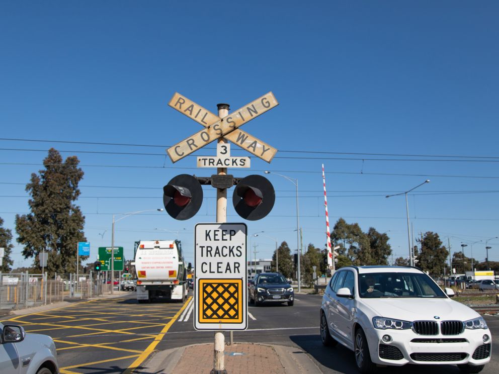 Cars passing through the level crossing at Old Geelong Road.