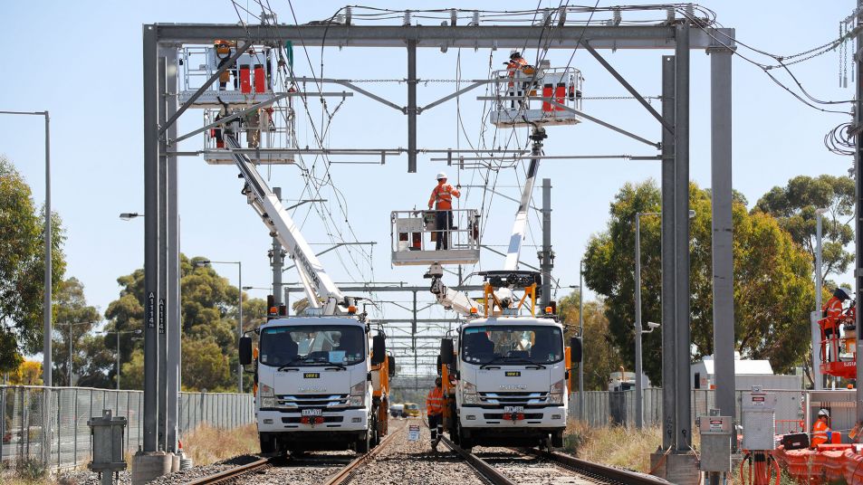 View of workers in cranes working on overhead lines on a rail track