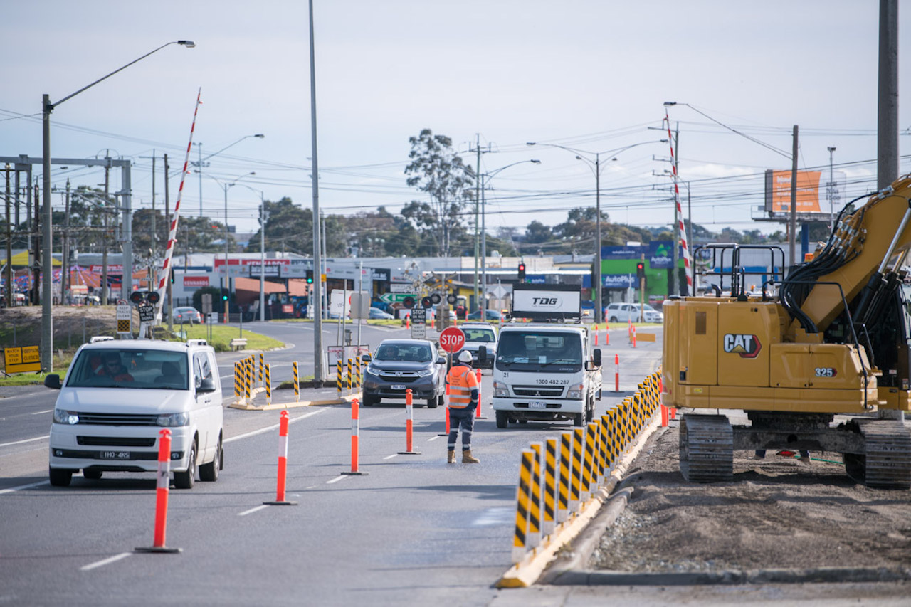 People in hi-vis orange directing traffic on a road.