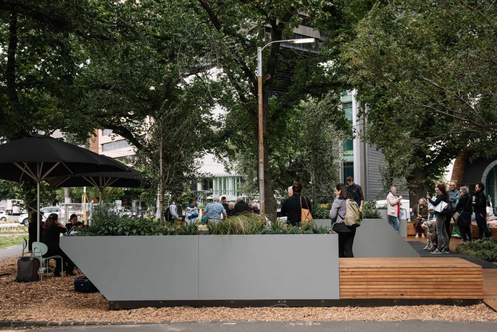 People enjoying a pop-up park made from timber decking and planters