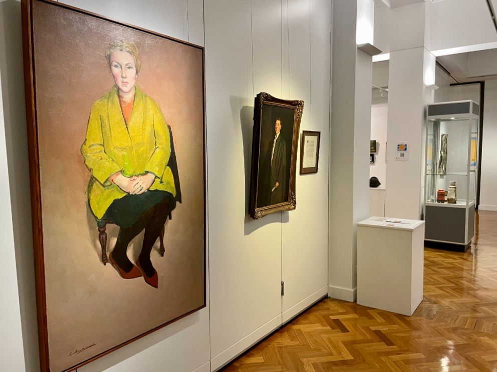 Art gallery room with painting of woman in yellow coat