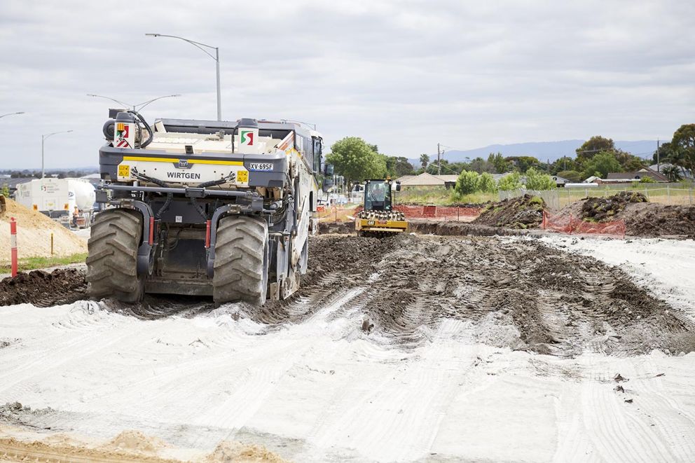 Cement being mixed with lime to achieve optimum material properties before constructing pavement