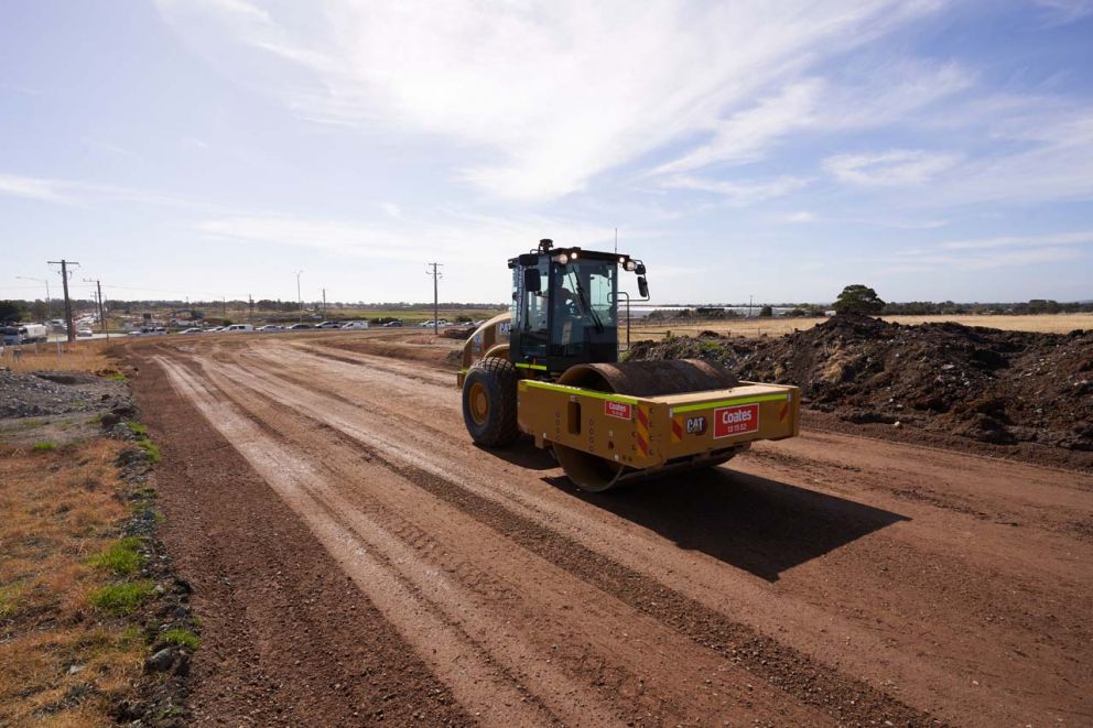 A smooth drum roller compacting the foundations of the new traffic lanes 