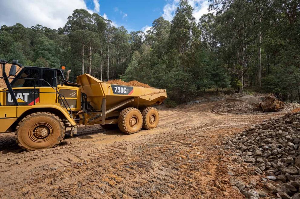 Articulated dump truck carts material away from landslip 31 March