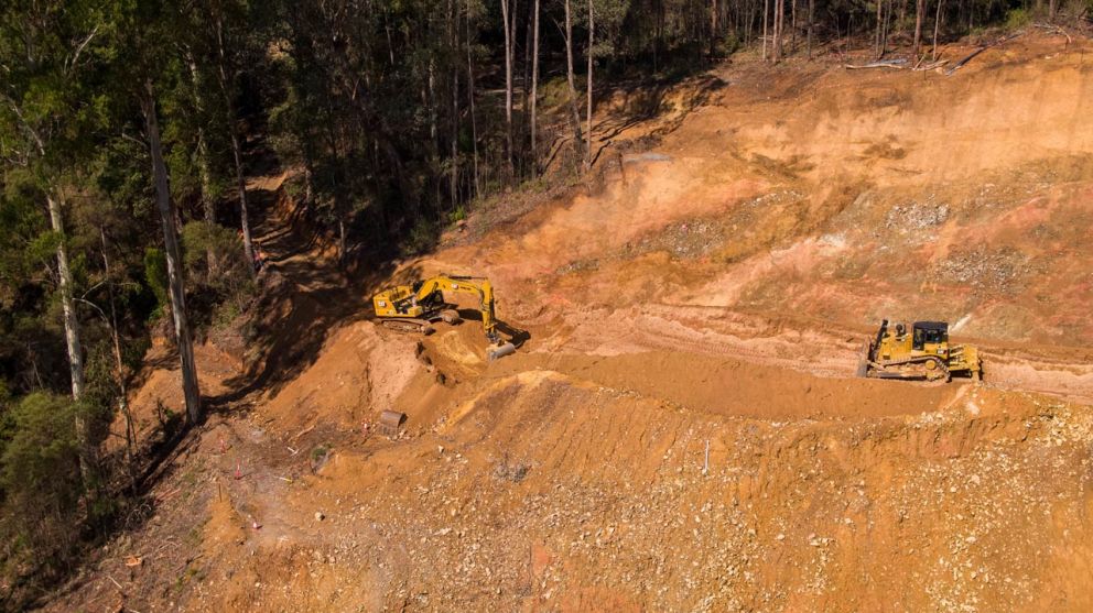 Excavator and D8 bulldozer shifting soil to be collected by trucks 24 March