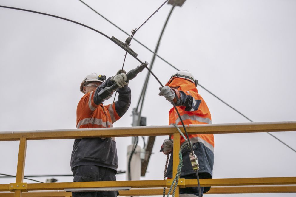 Workers cutting overhead wires