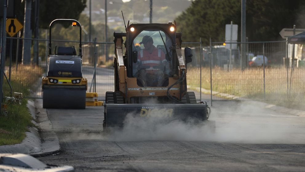 Steel drum rollers are used to compact and flatten out the asphalt and rock along Narre Warren North Road