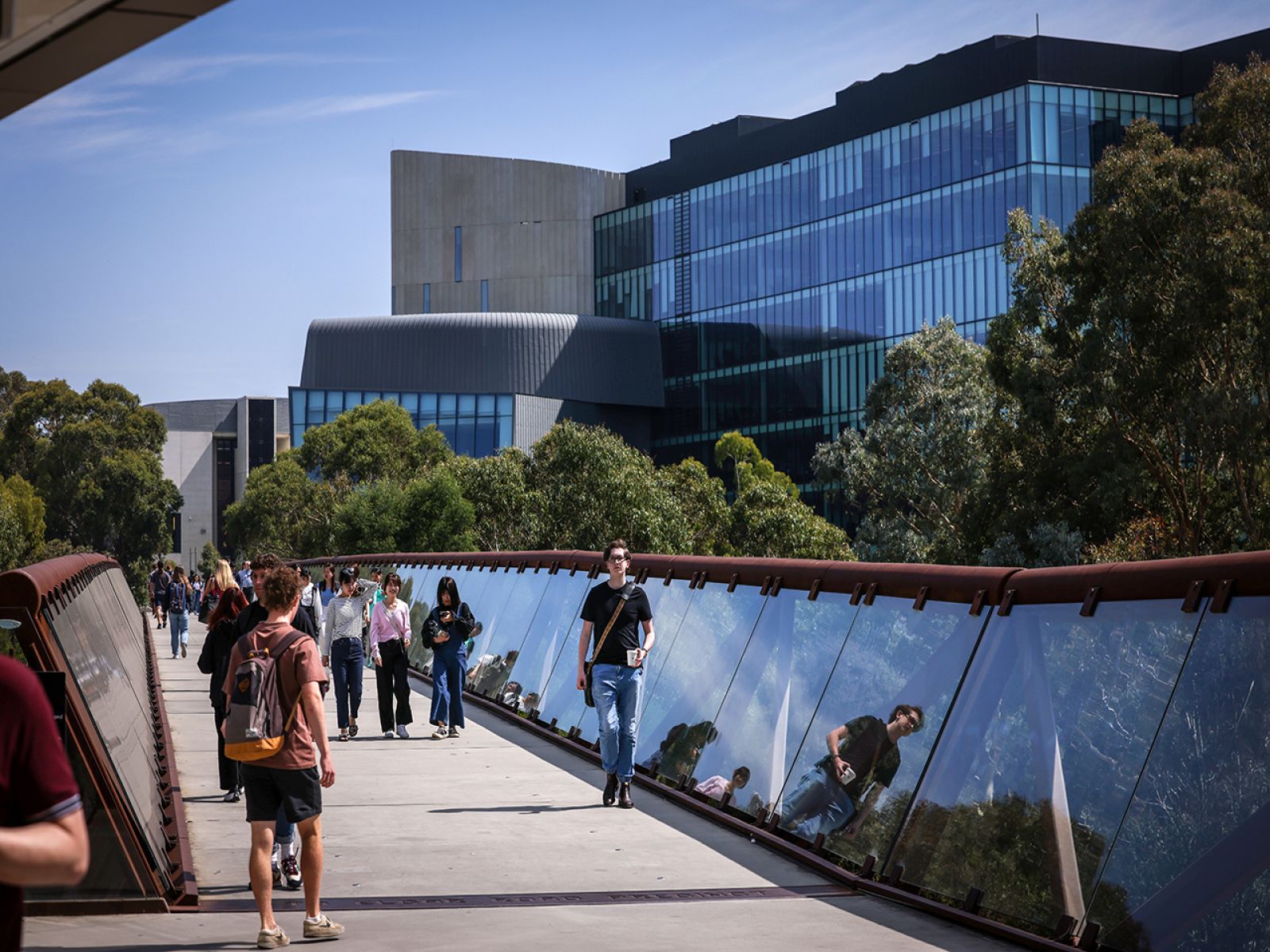 Image show pedestrians walking over a glass bridge in Burwood