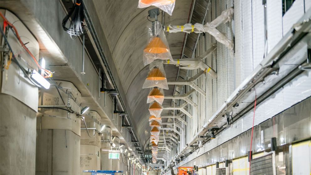 Row of light fixtures in wrapping at station platform level