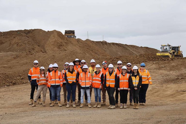 Ison Road Overpass team standing in front of the embankment that has been dug
