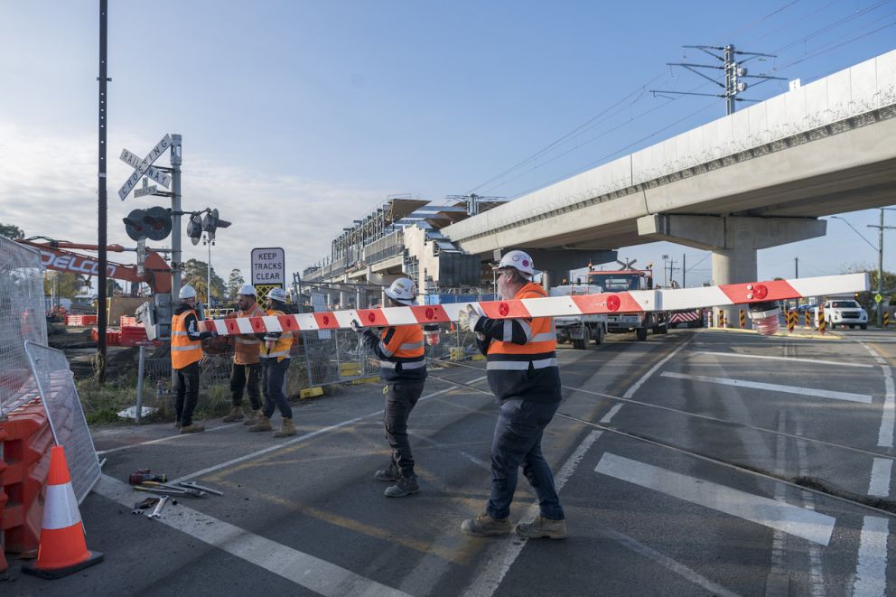 Workers removing the boom gate at Main Street level crossing