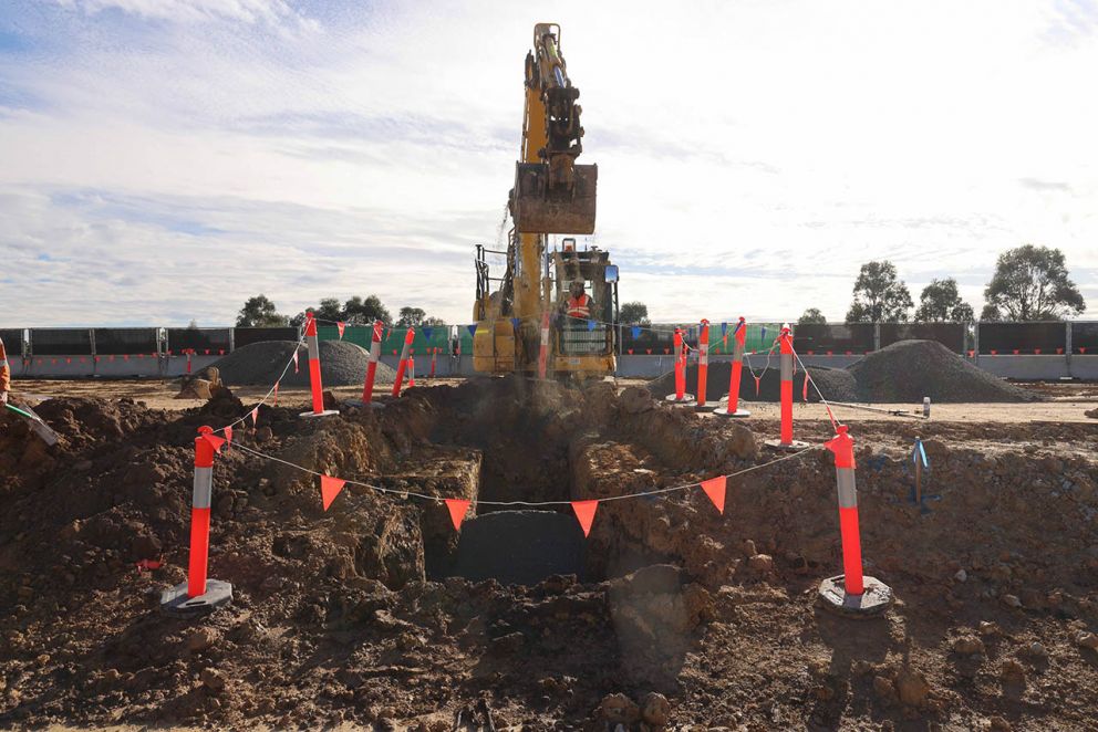 June 2023- An excavator digging a trench on site for utilities along the Princes Freeway