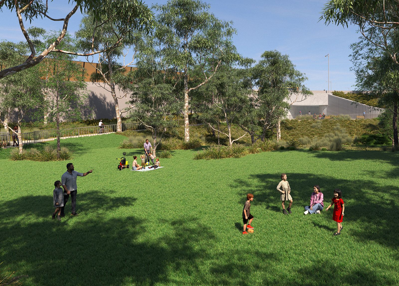 adults and children in green park with trees and buildings in the background. There is also a cyclist and someone walking on a path in the background