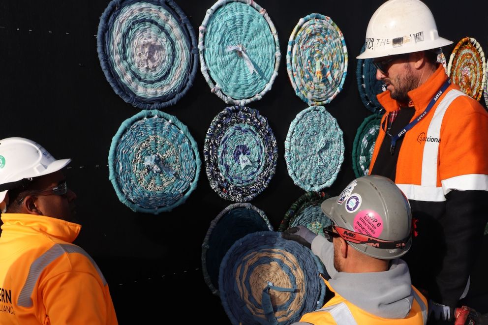 Not your usual construction project, workers install some of the 99 woven wheels