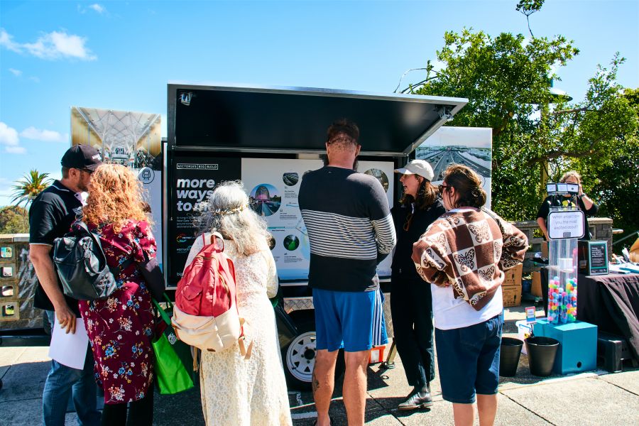 A group of people standing at an information cart learning about Big Build projects