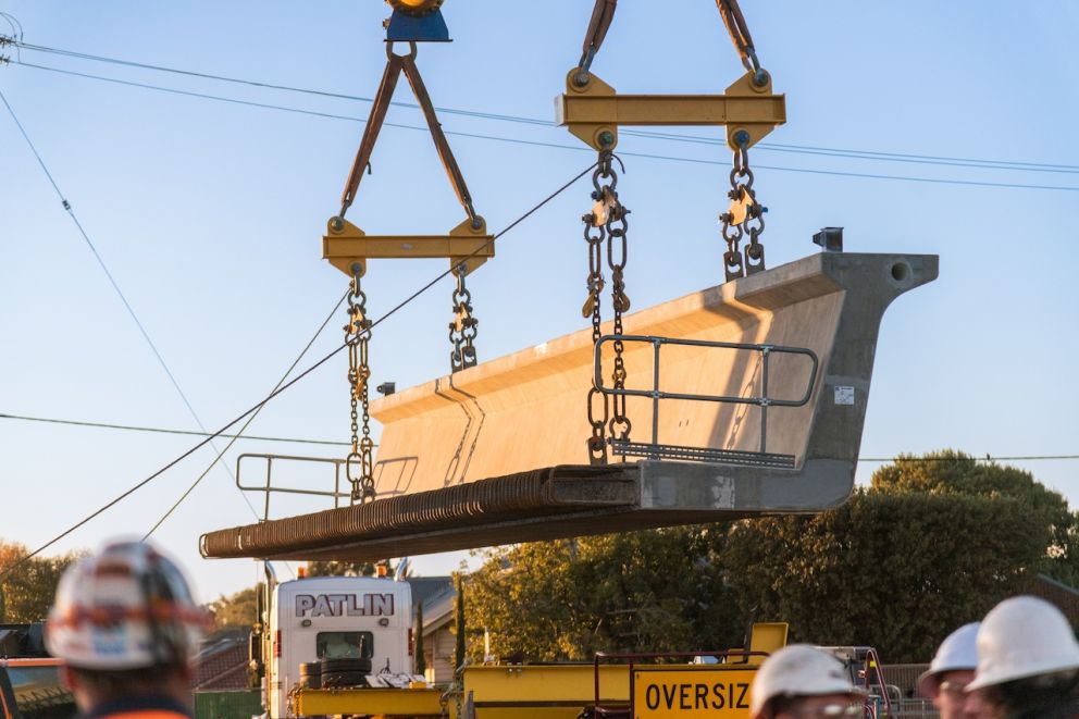 A 750 tonne crane lifts the first beam for the new rail bridge near Exford Road
