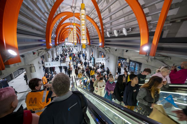Passengers on the escalator heading down to the platform. 