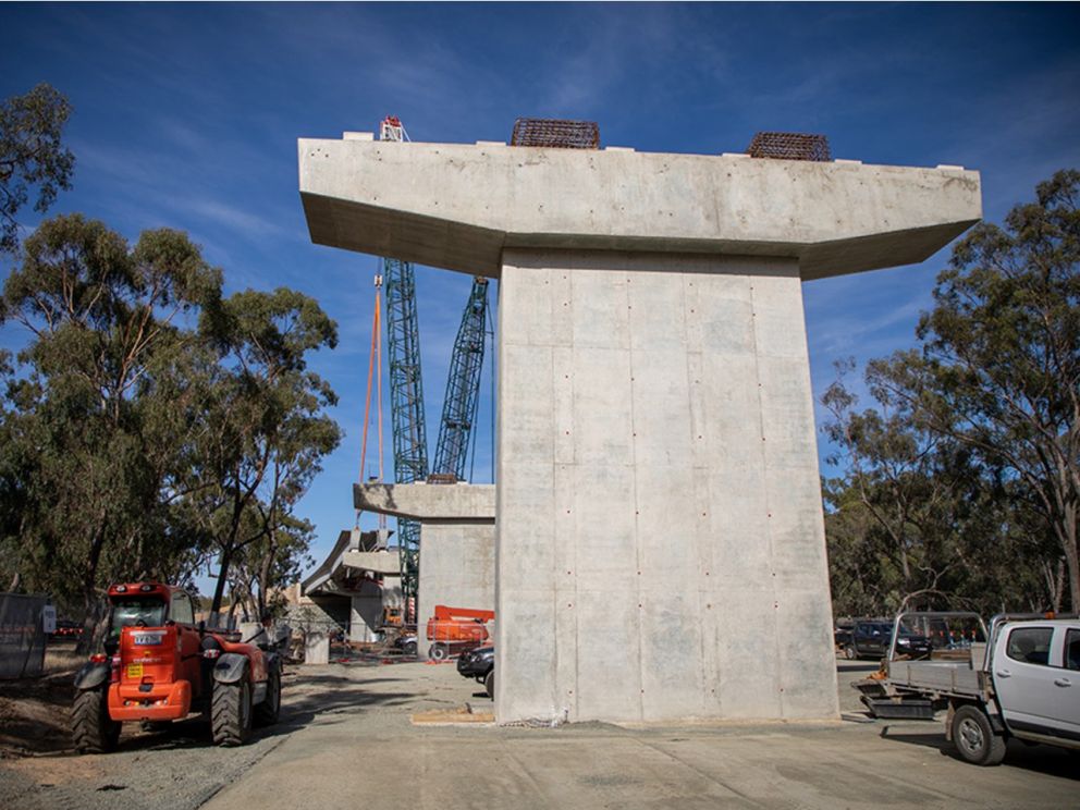 The piers and crossheads for the new bridge over the Murray River with construction vehicles surrounding it