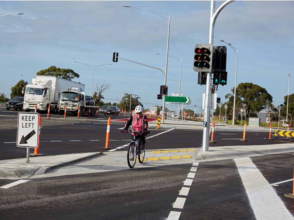 Image of a cyclist crossing the new intersection with traffic in the background