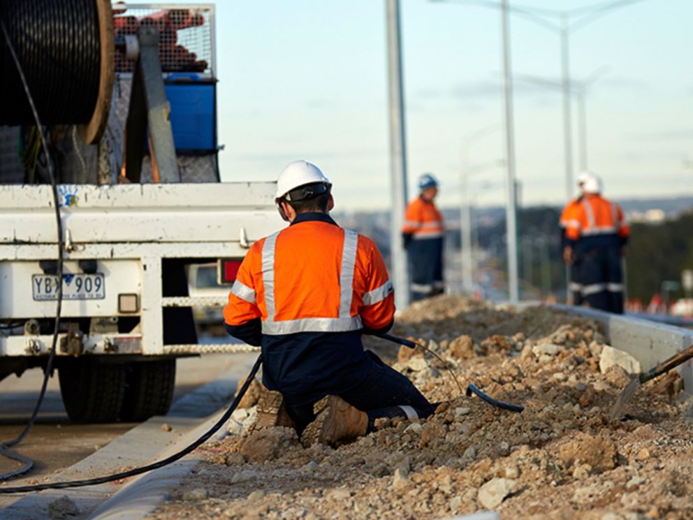 Image of a worker in the dirt working on the electrical wiring