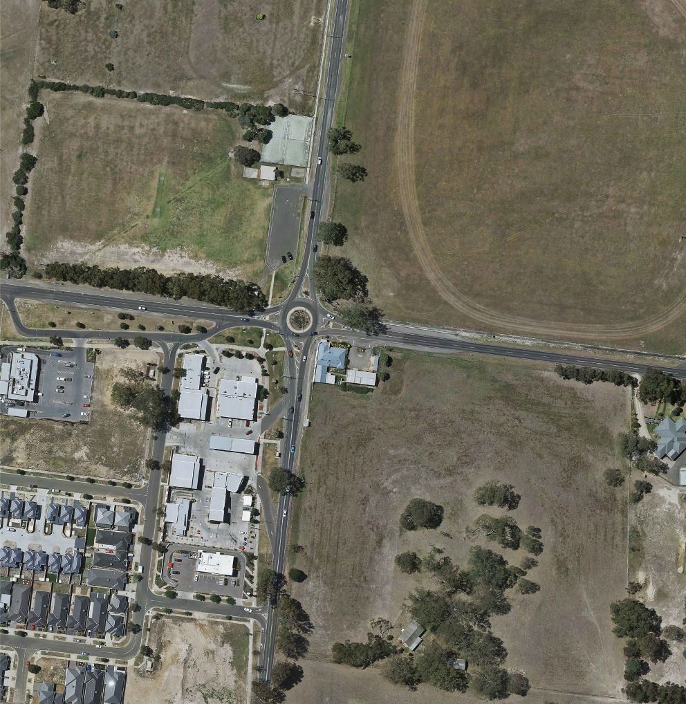 An aerial image of Bridge Inn Road intersection in its existing state. The bottom left corner has housing and property whereas the other areas surrounding the intersection is full of bare land.
