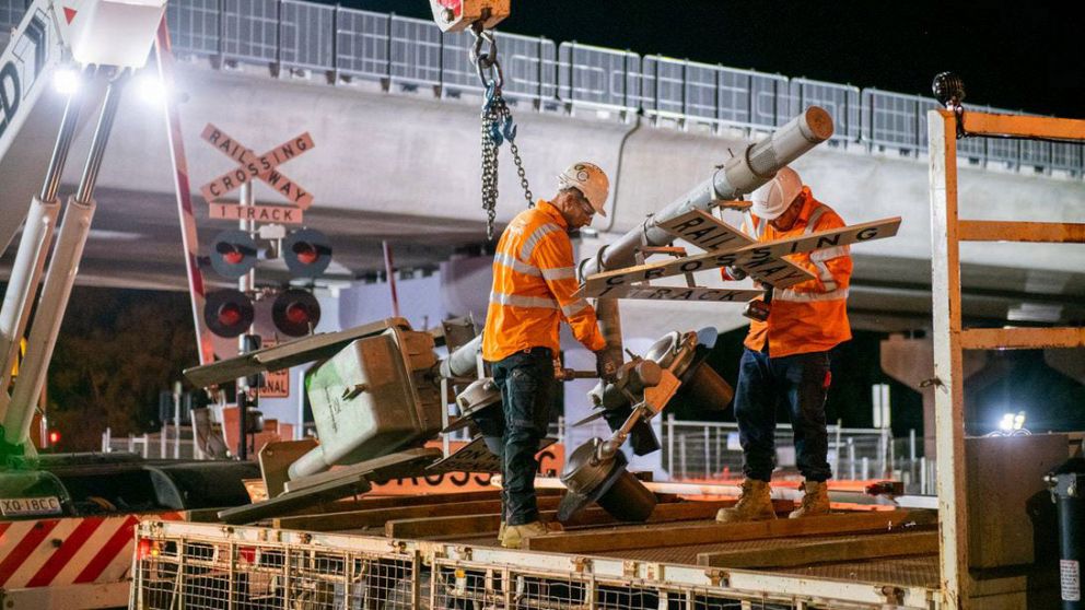 Workers remove the Werribee Street level crossing signage