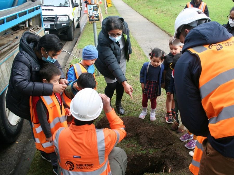 The kids and teachers look at the borehole in the ground