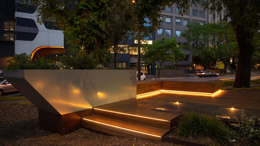 View of the Albert Road Reserve pop-up park at nighttime with lighting on the steps