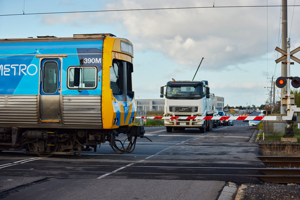 Traffic waiting at the Maddox Road level crossing as a train is passing through