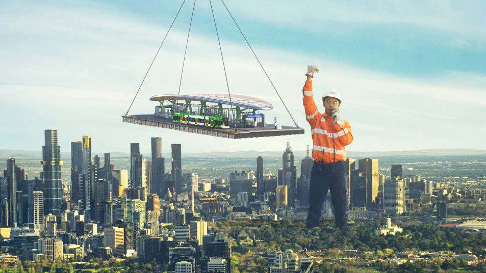 View of the Melbourne skyline, with an oversized worker in hard hat and work clothes helping to manoeuvre a new station suspended by a crane.