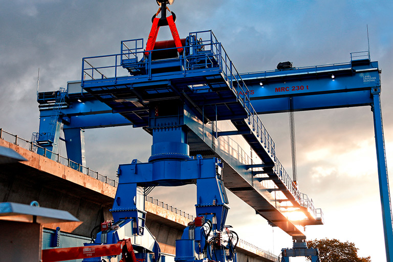 Large blue straddle carrier crane in the air