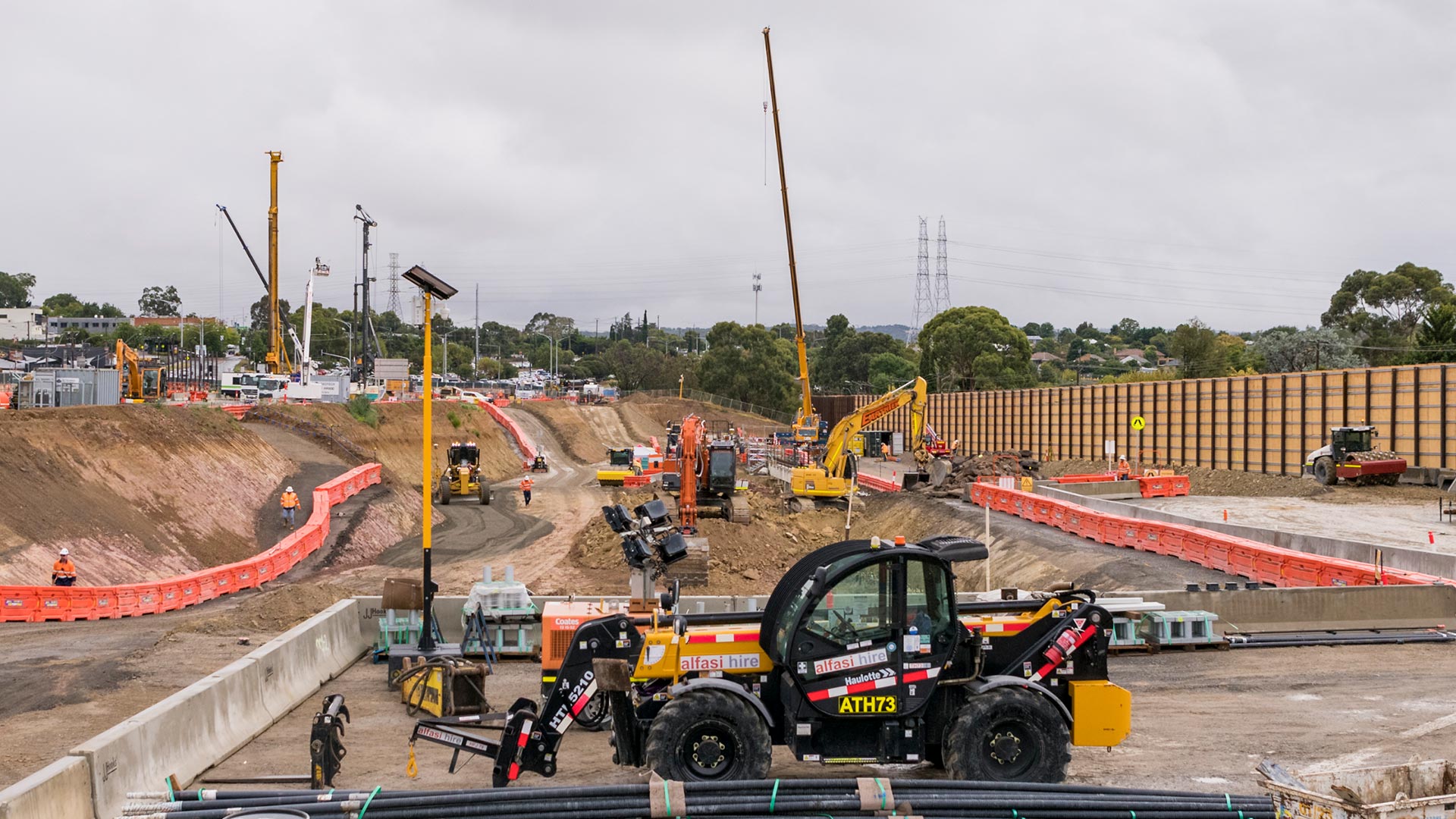 A North East Link construction site in Watsonia with machinery and construction equipment.