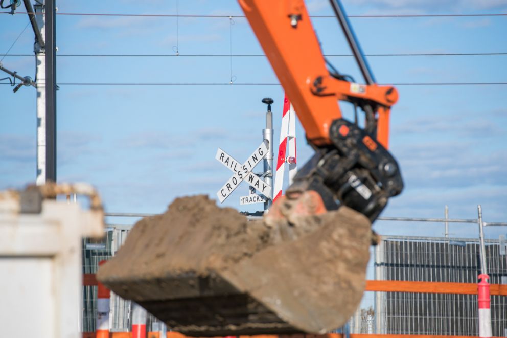 An excavator works near the level crossing