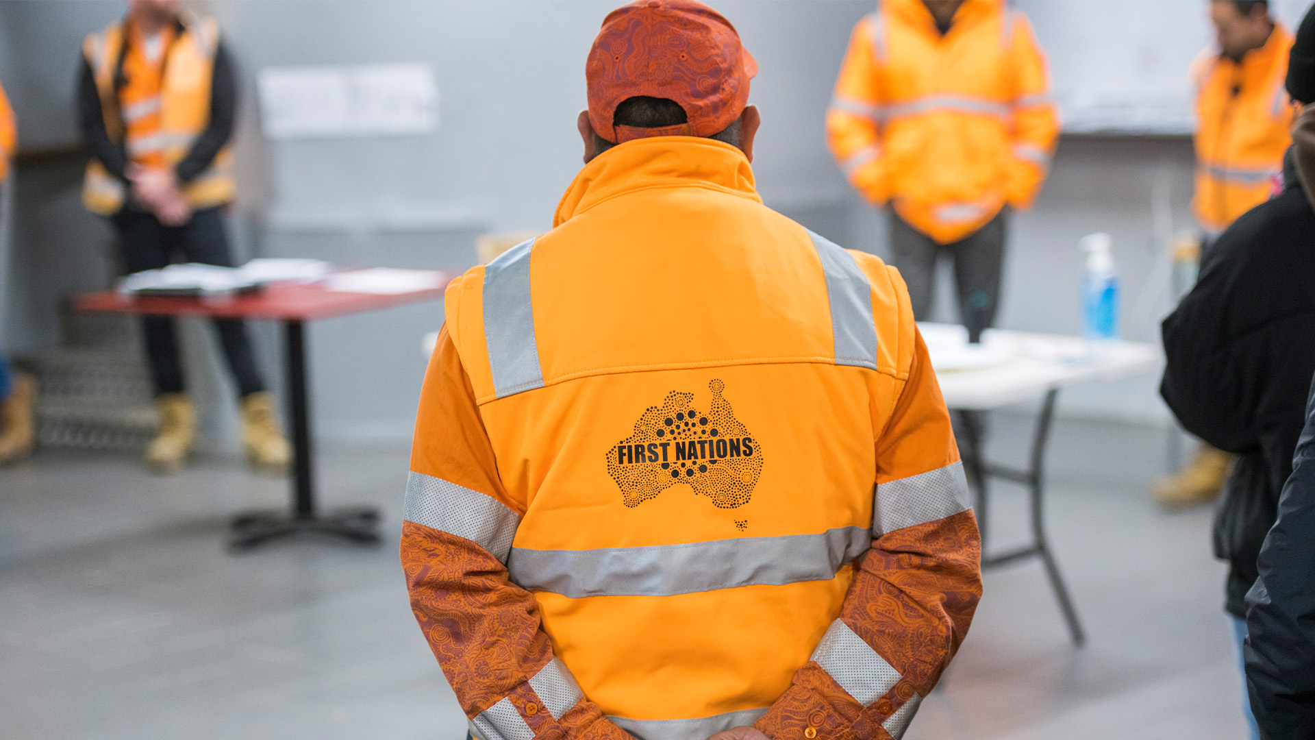 A worker in hi-vis clothing with back to the camera