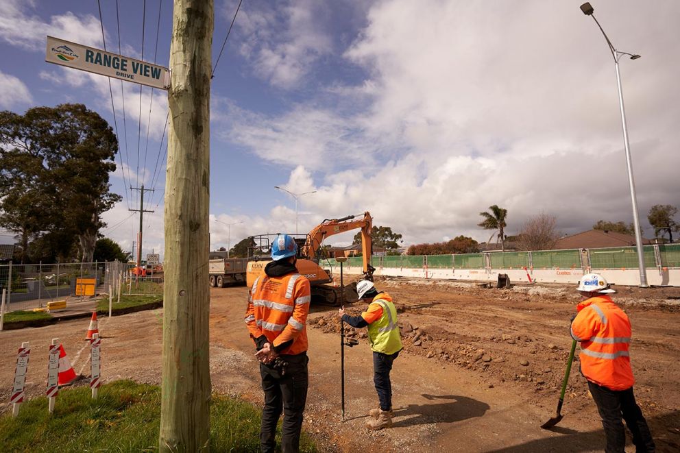 A spotter spotting, a surveyor surveying and a digger digging on the new road