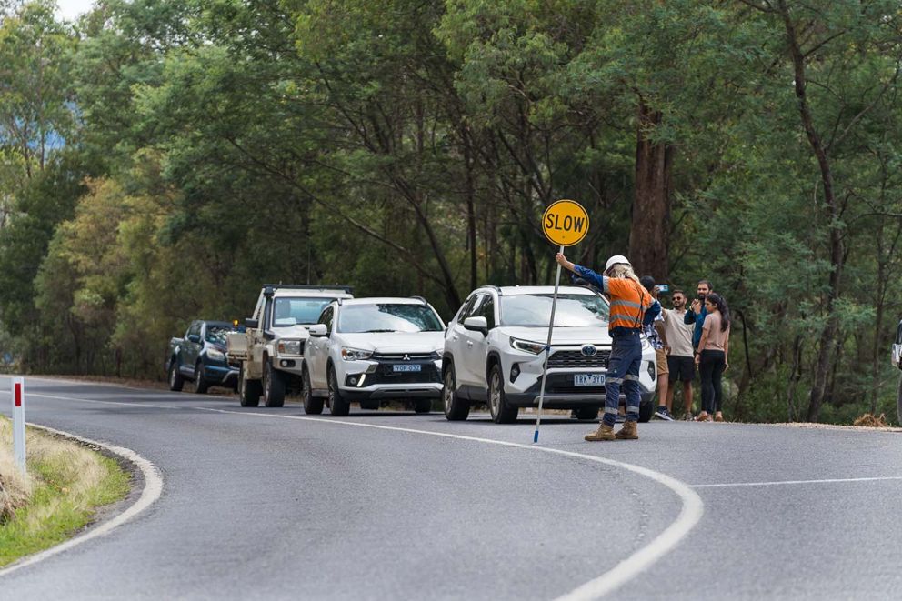 Cars halt at the direction of a traffic controller