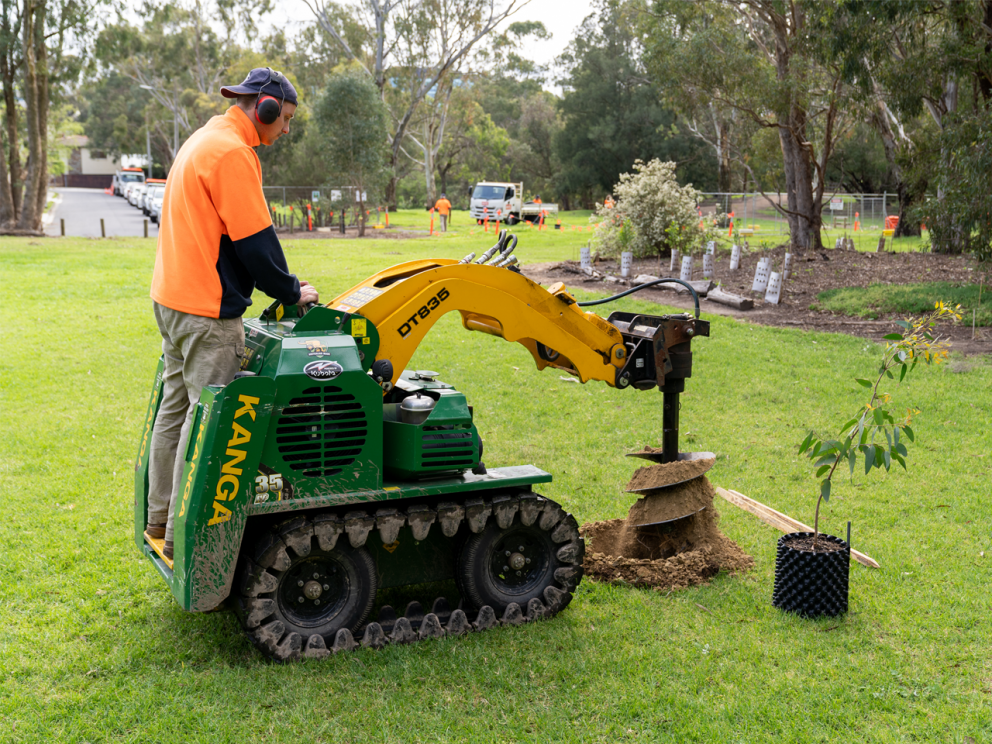 Crew member digging hole to plant trees