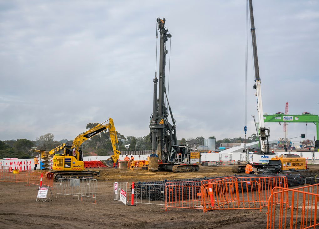 A construction site with machinery, cranes and safety barriers