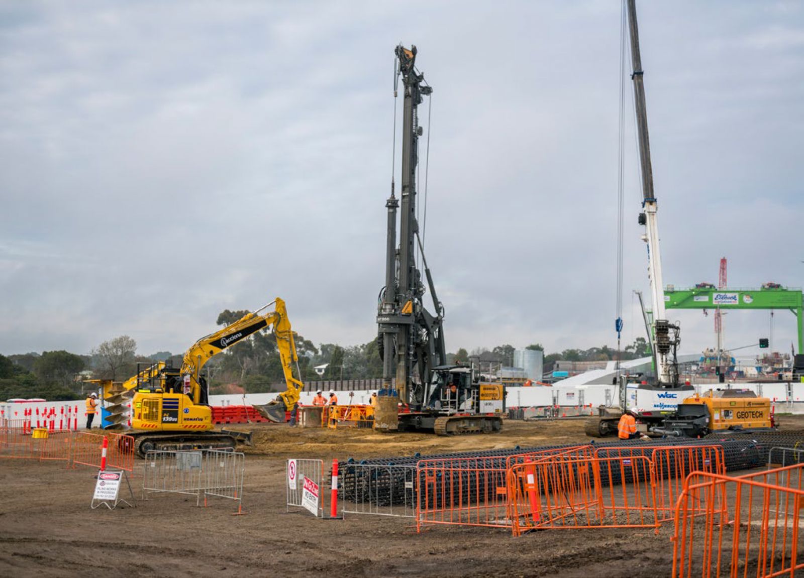 A construction site with machinery, cranes and safety barriers