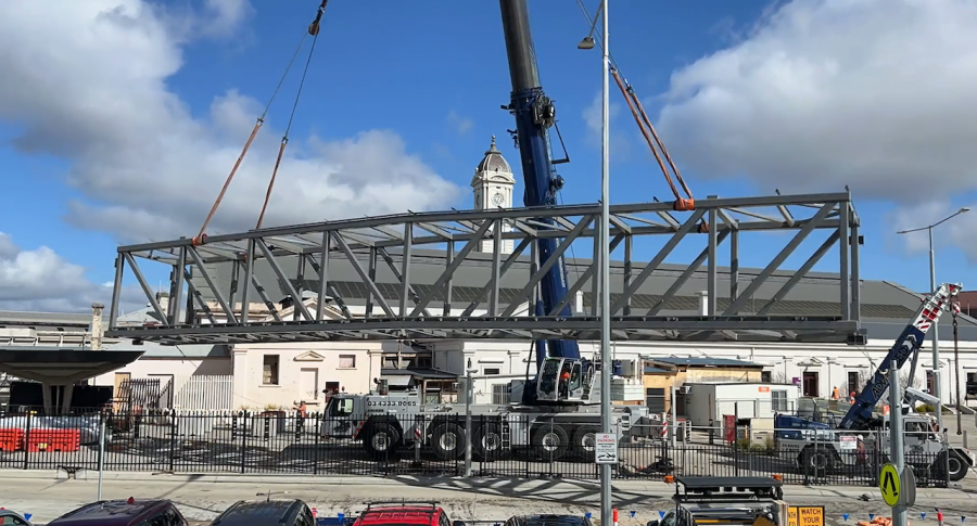 Pedestrian overpass is lifted off delivery truck