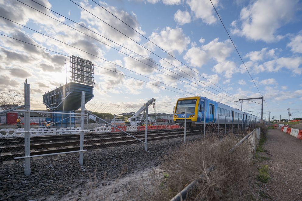 Works progressing alongside active rail operations, with the formwork of pier and crossheads installed