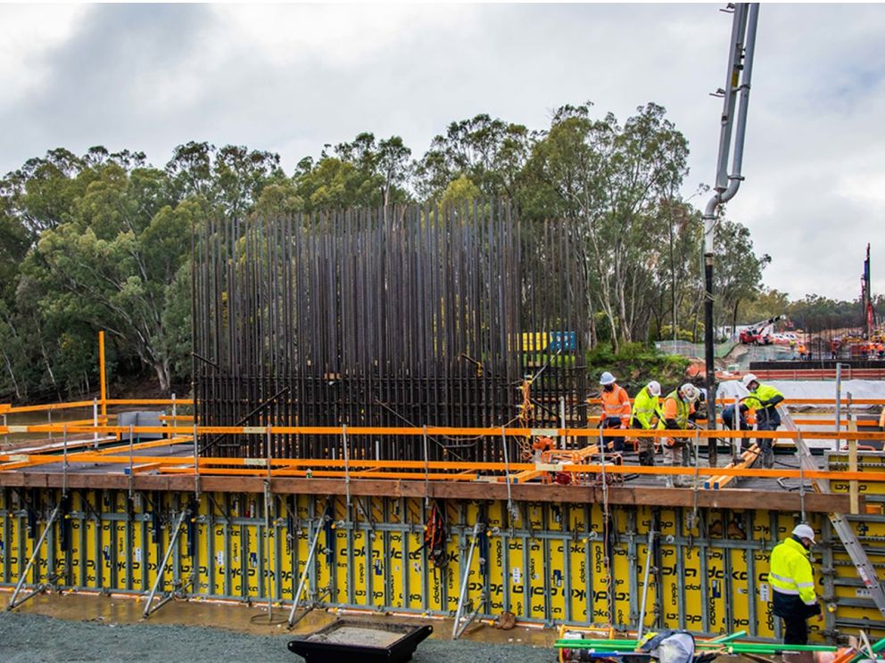 Image of workers assisting in the pouring of concrete for the bridge