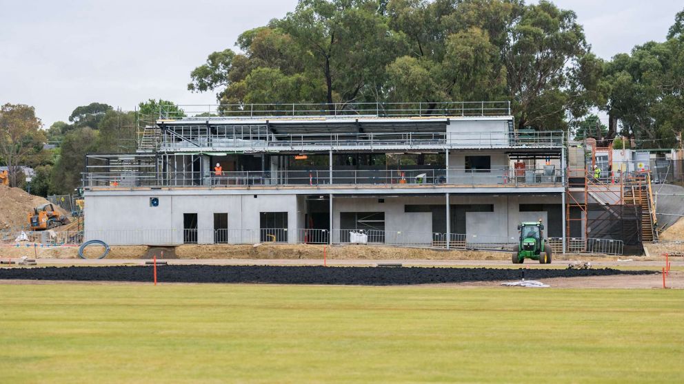View from Binnak Park oval looking towards construction of the new pavilion. Construction workers are on site and structural beams, walls and roofing is in place. 