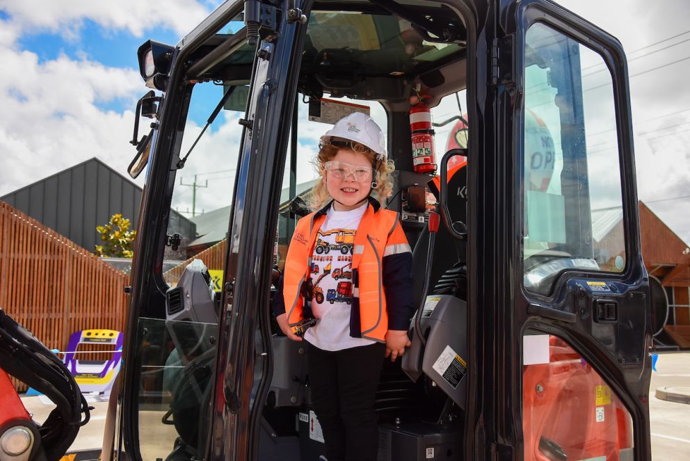 A girl smiling inside a digger.