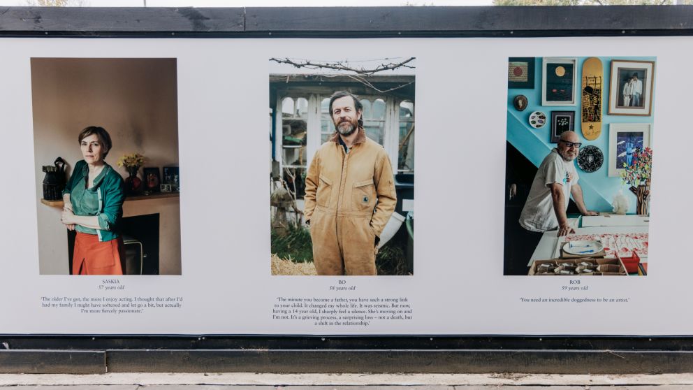 Photo of 3 of the portraits on the hoarding for the One Hundred Years project