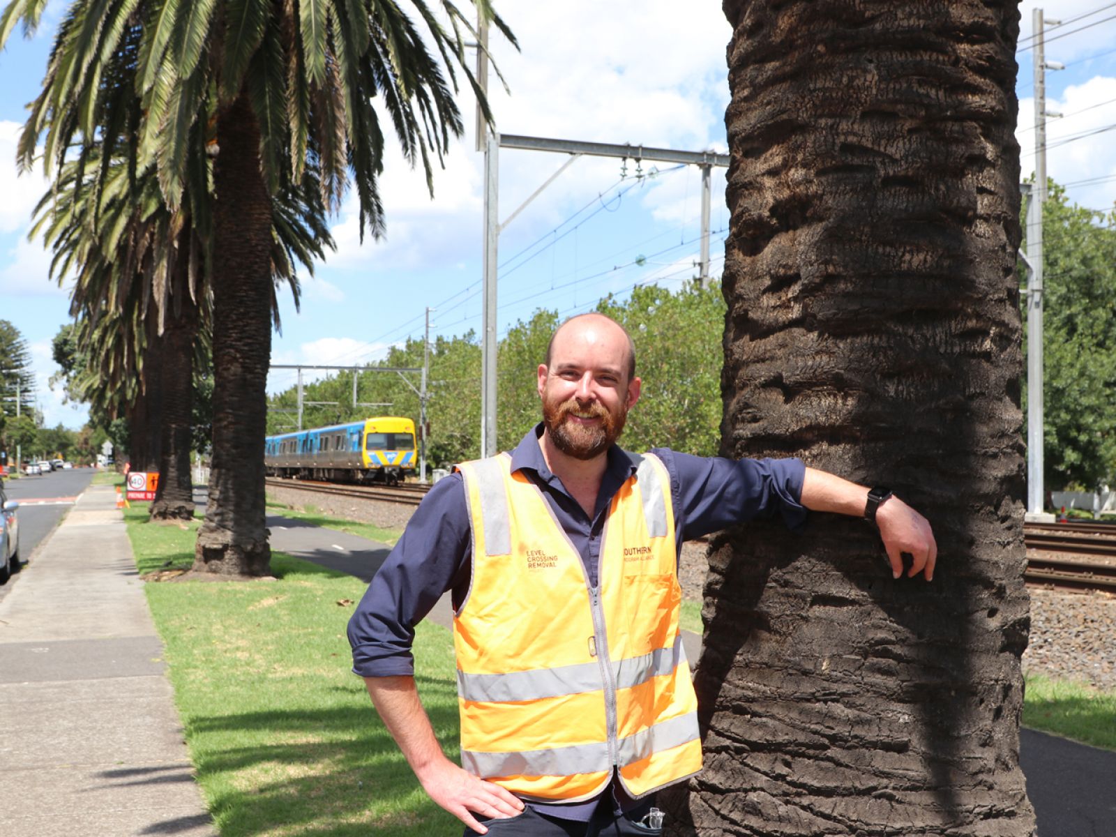 Man standing in front of large palm trees