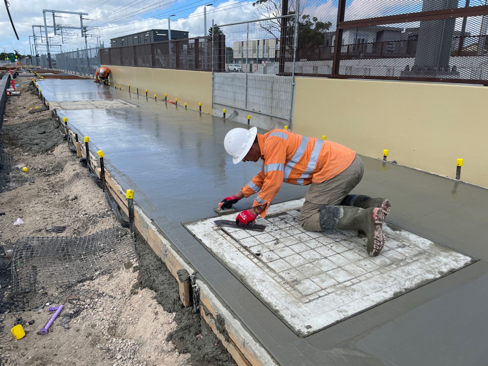 Man smoothing out concrete on the path.